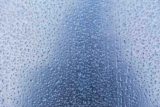 Water droplets or Rain Drops On Glass Textured Blue Background