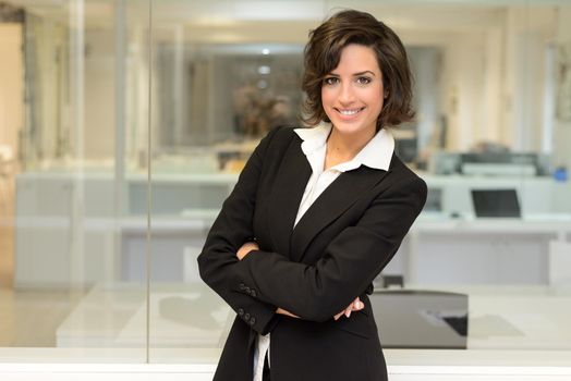 Portrait of a business woman in an office. Crossed arms