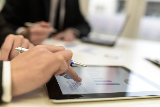 Close-up of a modern business team using tablet computer to work with financial data