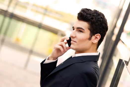 Portrait of a young businessman in an office building talking on the phone