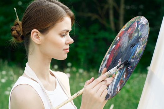 woman artist nature paints palette easel creative landscape. High quality photo