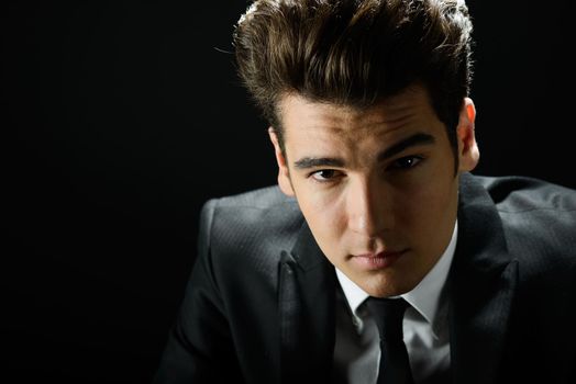 Portrait of a young businessman, isolated on black background