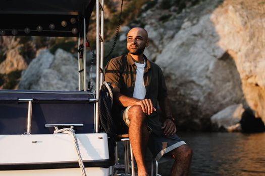 Young african american man relaxing on a sailboat in open sea at sunset, close up