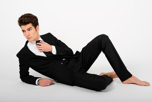 Portrait of a young businessman wearing a suit, barefoot, isolated on white background