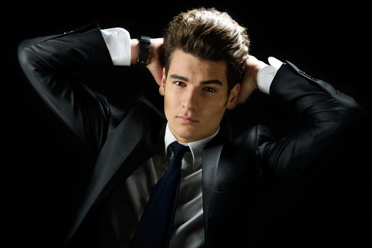 Portrait of a young businessman, isolated on black background