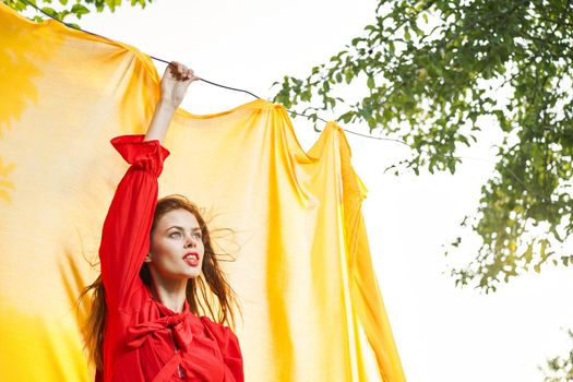 woman in red dress outdoors yellow bedspread. High quality photo