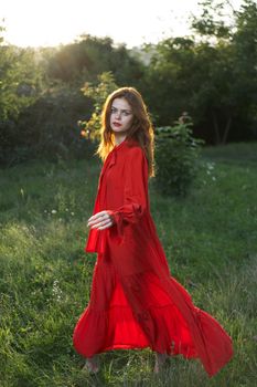 attractive woman in red dress outdoors in freedom field. High quality photo