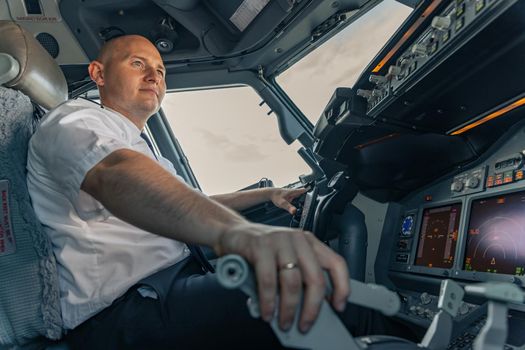 Low angle of a professional pilot sitting at aircraft steering wheel. Profession concept