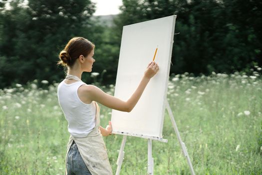 woman outdoors painting a picture creative art landscape. High quality photo