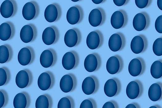 Pattern made of blue eggs on blue background. Minimal food concept. Flat lay, top view. Pop art design, creative easter concept in minimal style.
