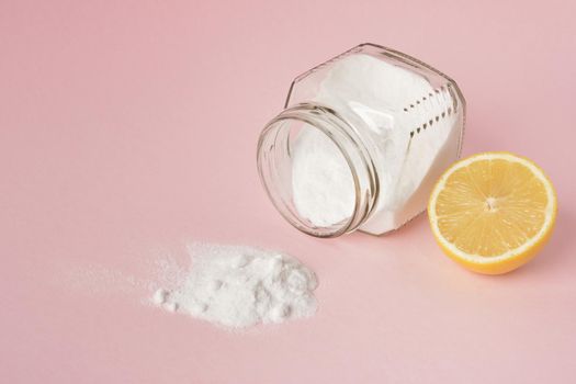 lemon and soda spilled from a glass jar on a pink background