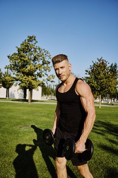 sporty man in black t-shirt in the park training lifestyle. High quality photo