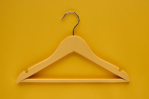 Wooden Coat hanger with black paper label isolated on yellow paper background. Clothing tag, label blank mockup template, to place your design. Black friday final sale banner.