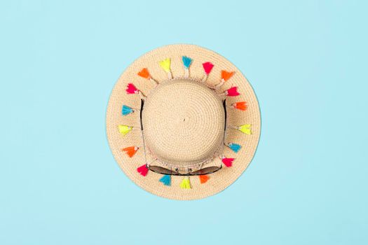 Minimalistic summer banner. Summer straw hat with sunglasses on pastel blue background.