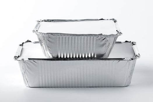 Foil food box with takeaway meal on white background close up