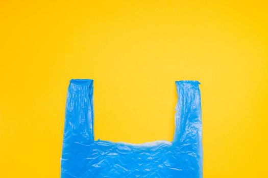 blue plastic bag on a yellow background copy space, top view, zero waste concept,say no to plastic, nature pollution