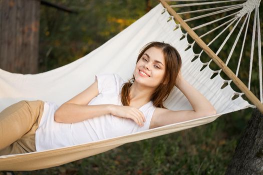 cheerful woman lies in a hammock rest nature fresh air. High quality photo