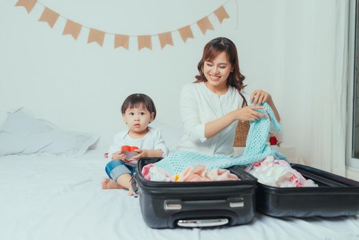  Mom and daughter are packing suitcases for the trip.