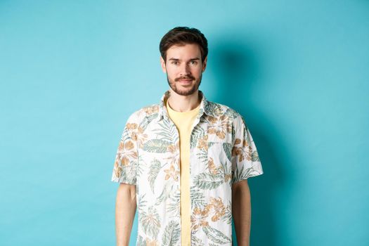 Happy handsome guy smiling, wearing hawaiian shirt on vacation. Concept of summer holiday.