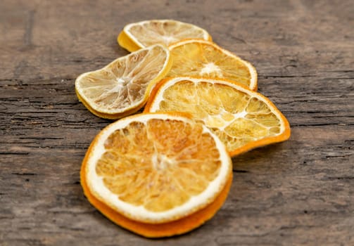 slices of dried oranges lying in the center of a wooden table. Idea for christmas card.