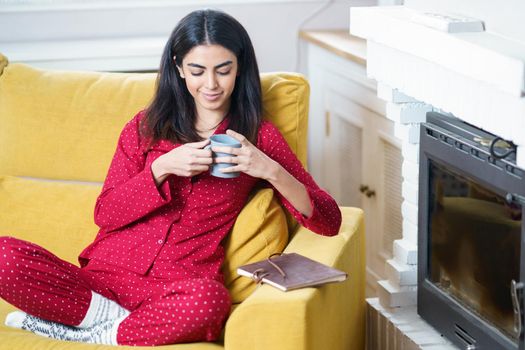 Persian woman at home having tea and reading