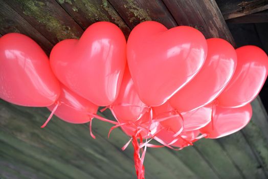 Red Heart Balloons for a Love Story at Valentines Day on a wooden background.coloured balloons forming a bright background wallpaper image.