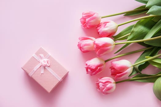 Pink Tulip flowers are arranged on a pink background. The view from the top, flat lay. Empty space for the text. Spring concept. Women's day. Mother's day.