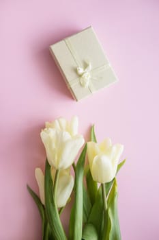 Yellow Tulip flowers are arranged on a pink background. The view from the top, flat lay. Empty space for the text. Spring concept. Women's day. Mother's day.