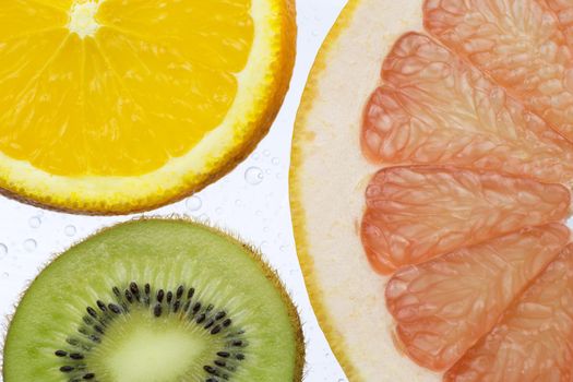 orange grapefruit and kiwi slices on white background