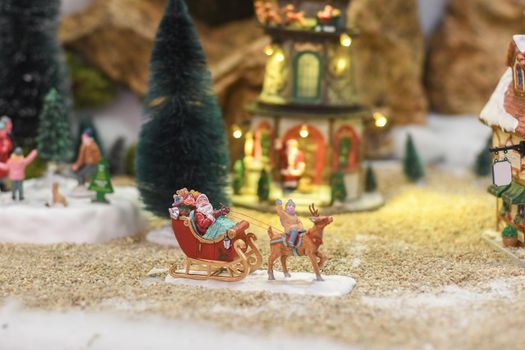 Santa Claus rides a sleigh with gifts Winter scene from ceramic figures