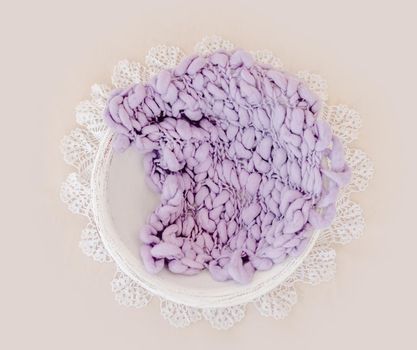 Beautiful backdrop for newborn photosession with flowers hydrangea. Digital composite with basin filled with knitted blanket isolated on light pink background. Top view