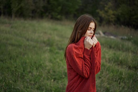 woman outdoors in a red sweater cool nature. High quality photo