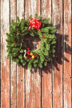 Christmas wreath with decorations on the shabby wooden door.