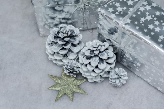 Cones in the snow and presents in silver packing for Christmas
