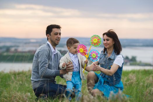 Portrait of a family of three at evening hill, telephoto shot