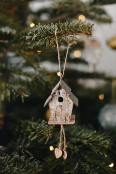 A wooden birdhouse hanging on the Christmas tree