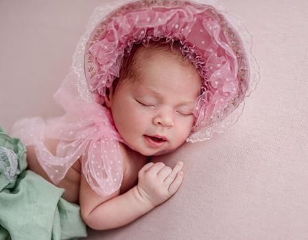 Funny newborn wearing lace cap and pantaloons