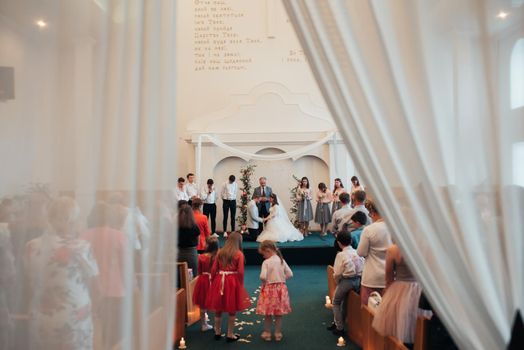 SACRAMENTO, USA - MAY 12 th 2018: Bride and groom pray and receive blessings in the church building.