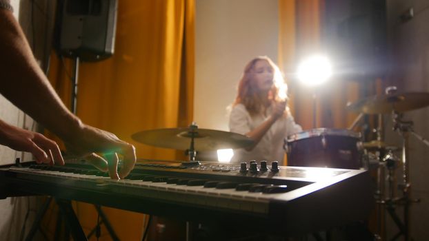 Repetition. Girl drummer and a guy on keyboards. Studio