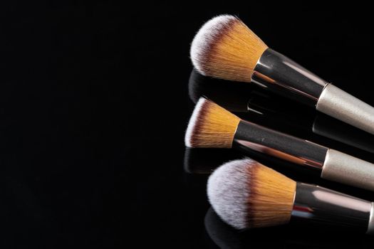 Collection of make up brushes on black background, close up