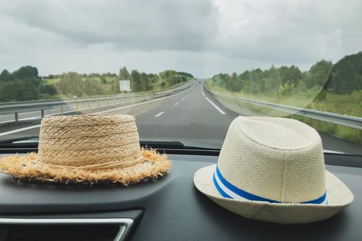 Two straw hats in the car Rural landscape outside the window