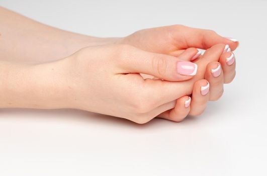 Well-groomed female hands with manicure on white background close up