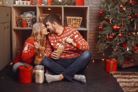 People in a Christman decorations. Man and woman in a red sweater. Family in a kitchen.