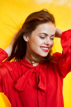 smiling woman in red dress posing yellow background. High quality photo