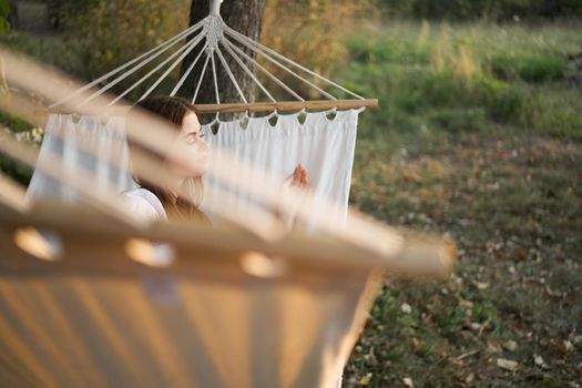 woman relaxing in nature in a hammock garden fresh air. High quality photo