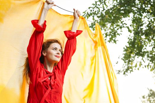 woman in red dress outdoors yellow bedspread. High quality photo