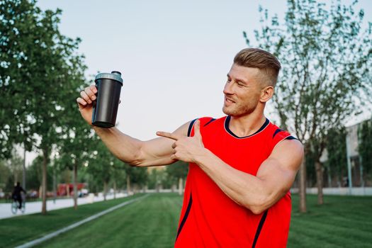sporty man in the park outdoors glass with drink. High quality photo