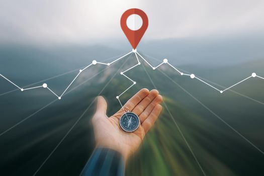 Male hand with compass and connected location GPS pin in summer mountains outdoor, point of view. Navigation concept. Image with moving fast and motion blur effect.