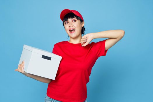 woman with box in hands delivery courier blue background. High quality photo