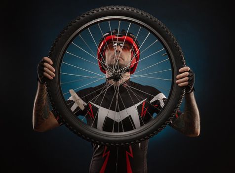 guy-cyclist in a Bicycle helmet with a Bicycle wheel